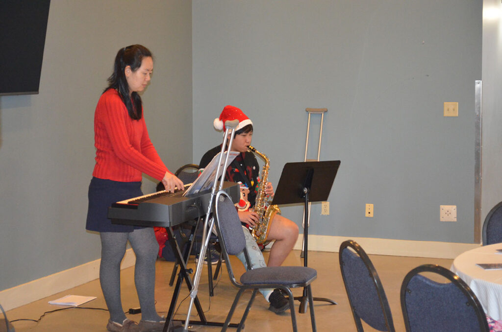 PHS 2023 Mental Health Christmas Party. Woman and teen boy playing christmas carols